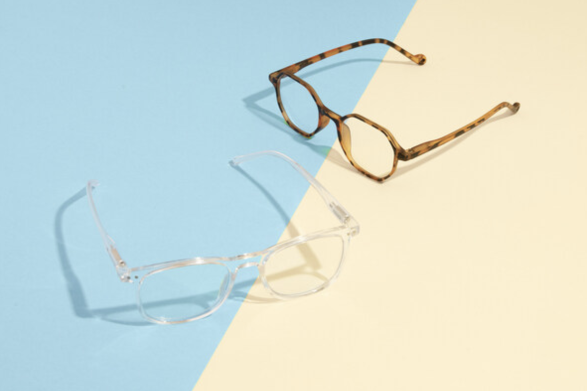 Clear and tortoiseshell eyeglasses on a two-tone blue and beige background